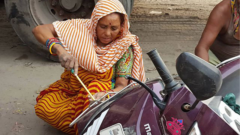 Indian woman mechanic working on a motorcycle